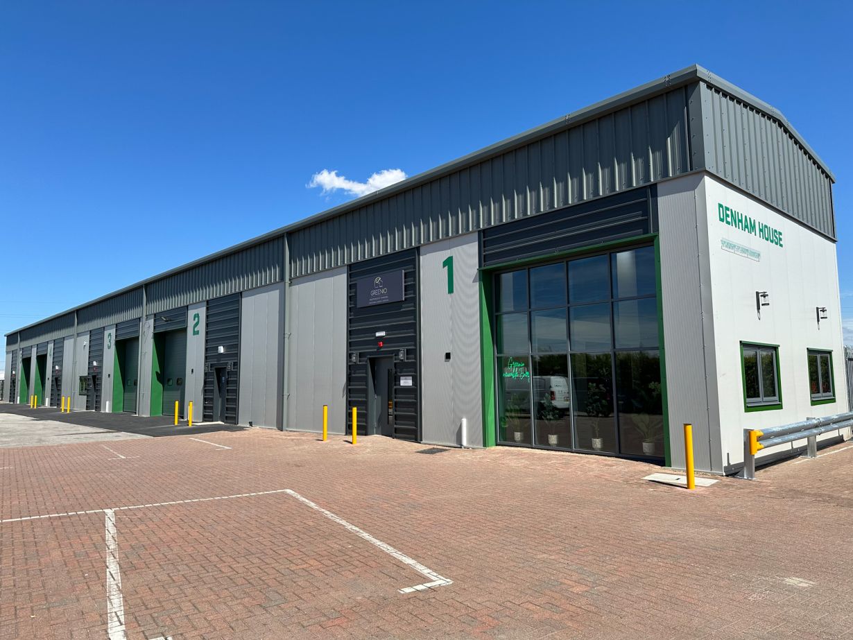 Exterior of a modern industrial building with multiple units, labelled 1 to 3, under a clear blue sky. The sign reads 'Denham House